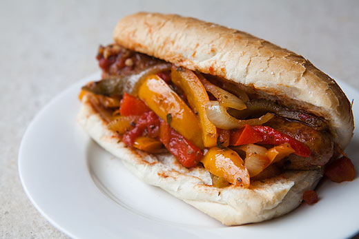 Italian sausage on a roll with onions and peppers.