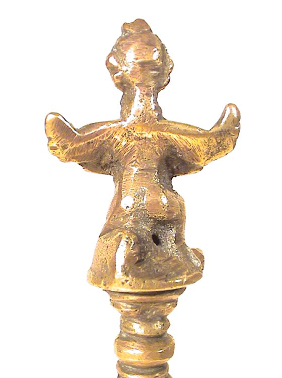 Rear view of the figurine on the handle of the bronze bell.