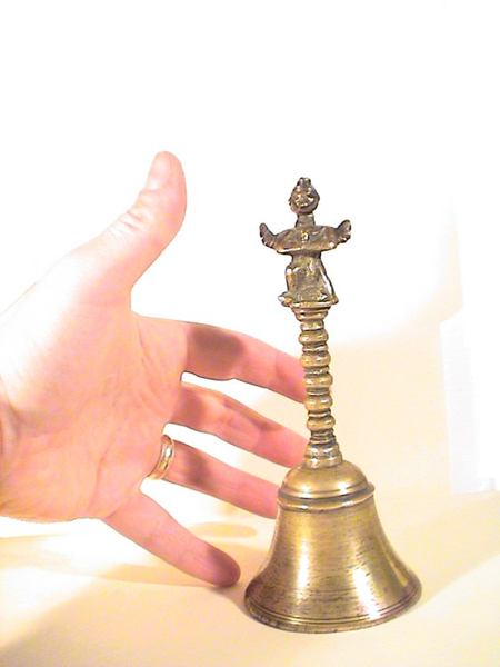 The mysterious bell with hand to show comparative sizes.