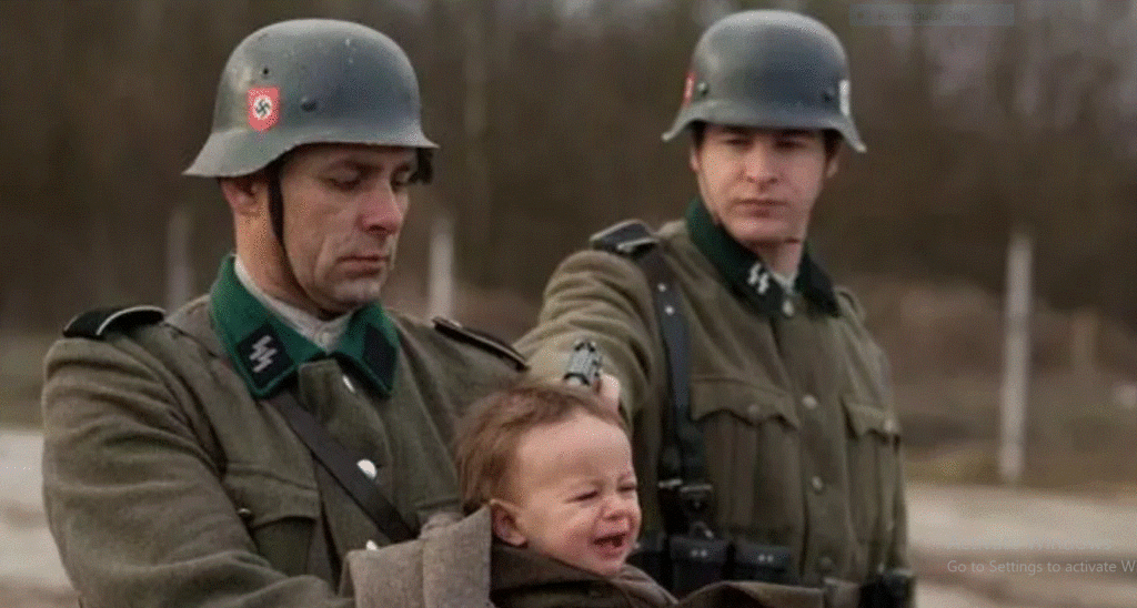 German holding up a gun to an infant.