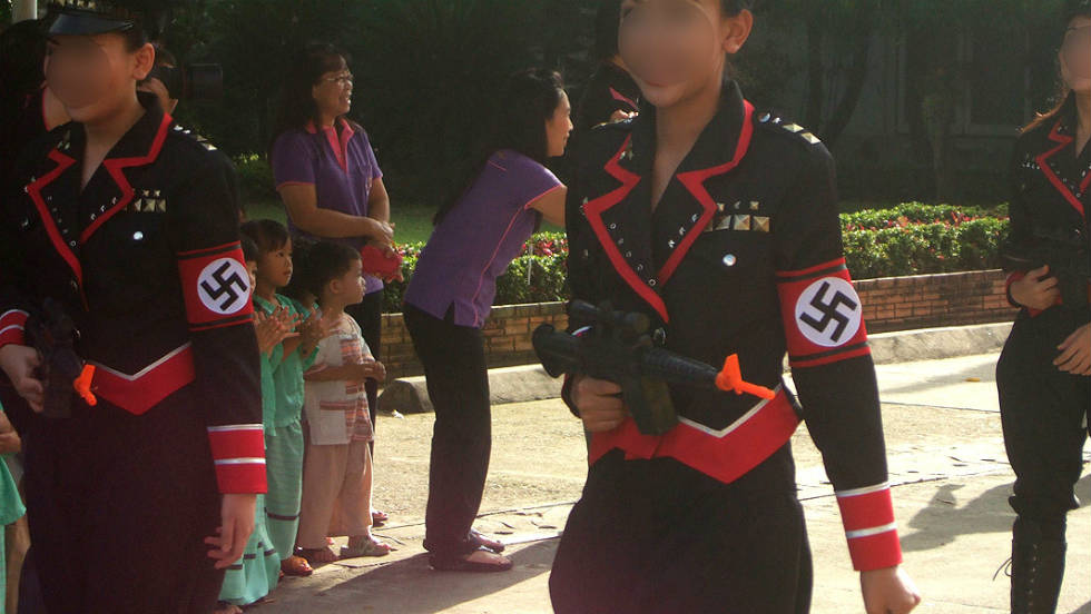 Nazi themed parade in Thailand. Pretty girls with toy automatic weapons, and Nazi style clothes make up this very popular parade. As they are all very fashionable.