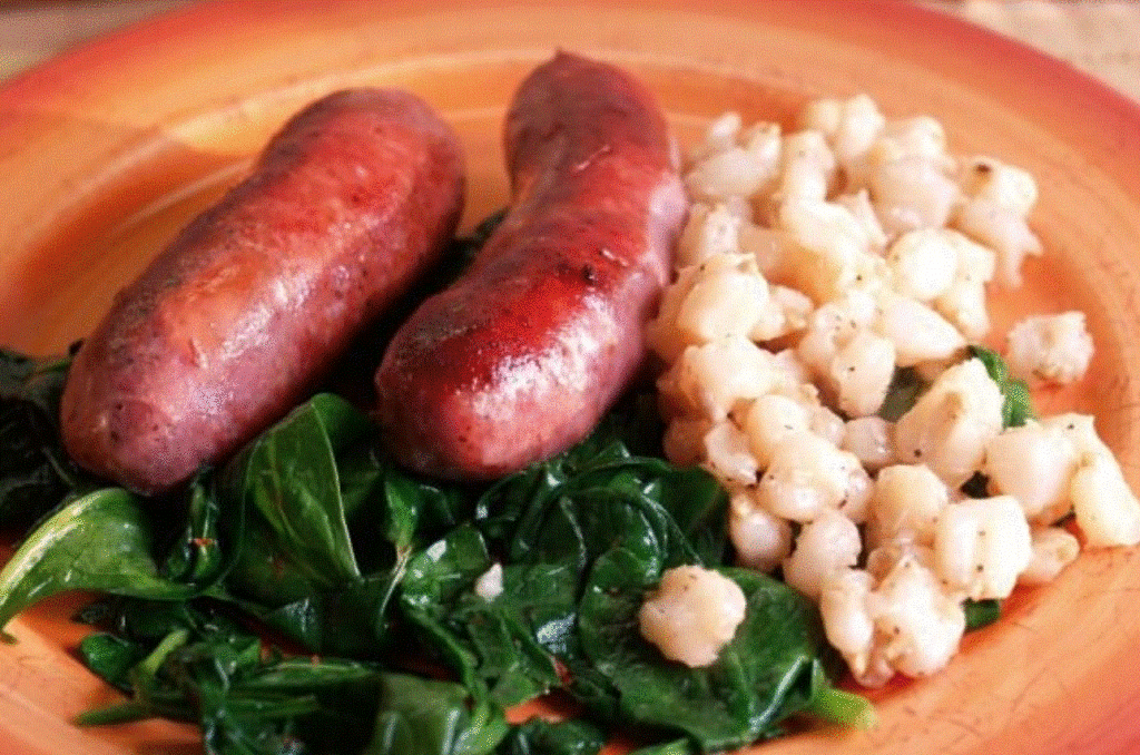 --PHOTO--This is a full meal ready to go. The underrated hominy takes in the flavor of the roasted sausages; spinach cooked with garlic and chili flakes makes a perfect green addition to the plate. Seconds, please! 