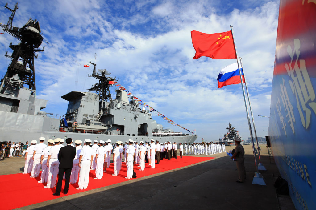 In this photo released by China's Xinhua News Agency, officers and soldiers of China's People's Liberation Army (PLA) Navy hold a welcome ceremony as a Russian naval ship arrives in port in Zhanjiang in southern China's Guangdong Province, Monday, Sept. 12, 2016