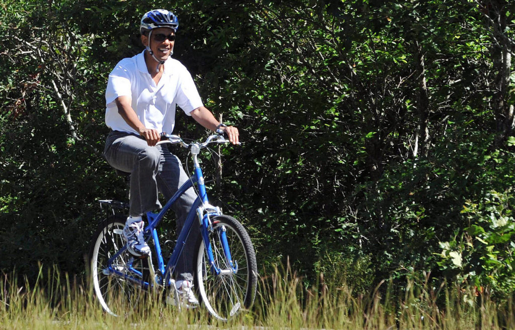 President Obama showing his strength and leadership skills by riding a bicycle.