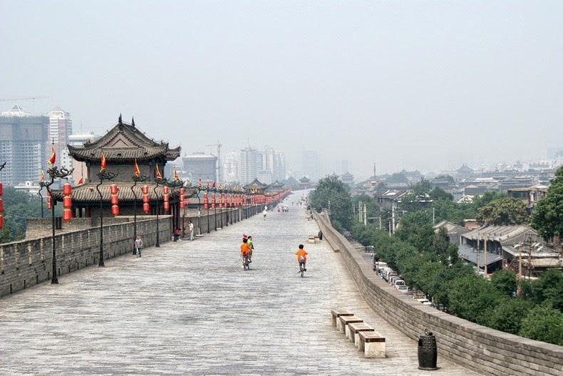 The original Xi’an city wall was started in 194 BCE and took 4 years to finish. Upon completion, the wall measured 25.7 km in length and 12–16 m in thickness at the base, and enclosed an area of 36 square km. The first city wall was built of earth, quick lime, and glutinous rice extract, tamped together. Later, the wall was totally enclosed with bricks.

Xi’an's city wall, after its enlargement in the Ming Dynasty, stands 12 meters high. It is 12-14 meters across the top, 15-18 meters thick at bottom, and 13.7 kilometers in length and encircles an area of roughly 14 square kilometers within the city. There is a rampart every 120 meters that extend out from the main wall and allow soldiers to see enemies trying to climb the wall. The distance between every two ramparts is just within the range of arrow shot from either side.