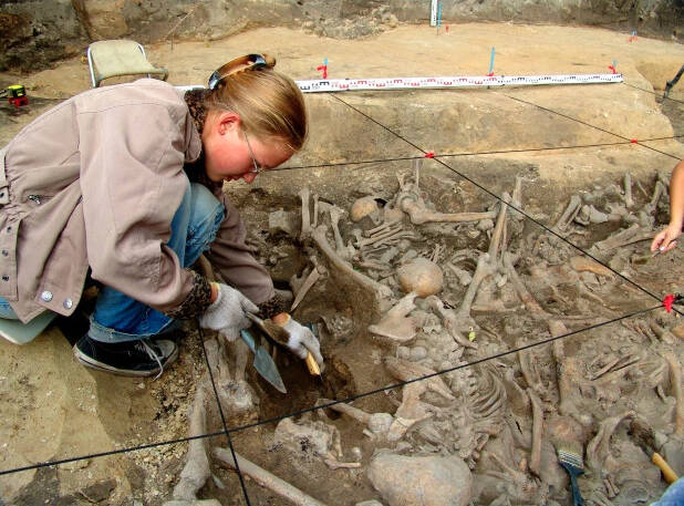 An archeologist examines the remains at the Yaroslavl massacre site.