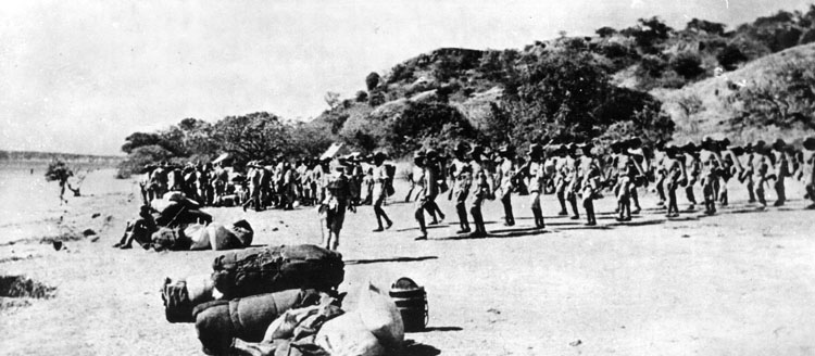 After coming ashore on Madagascar, British soldiers of the King’s African Rifles assemble on the beach.