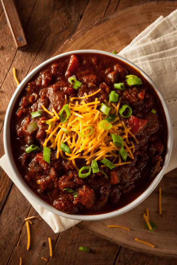 Bowl of Chili with Beans Cheese and Onions 683x1024