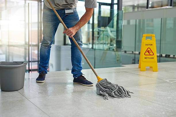 Shot of an unrecognizable man mopping the office floor