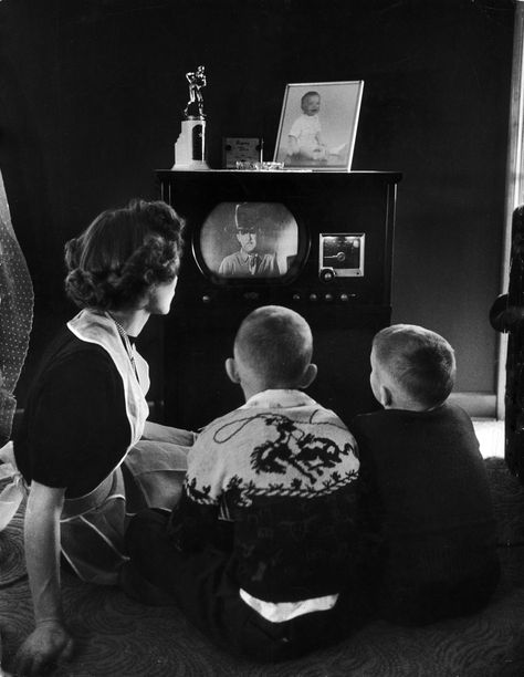 Mother and two children sitting on floor of living room